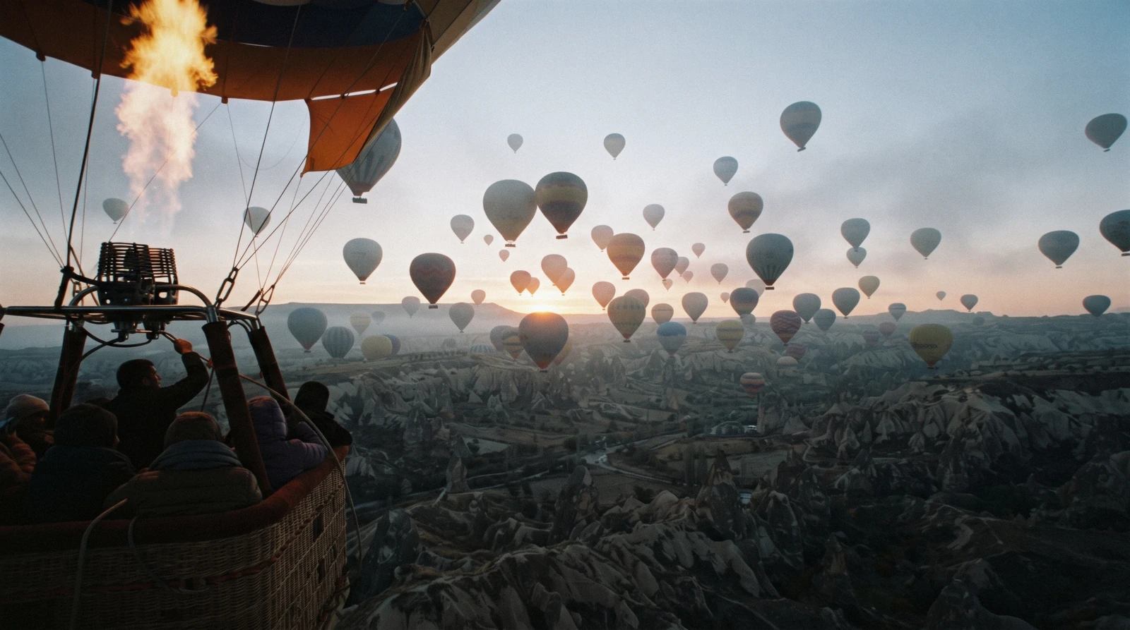 Hot air balloons rising at sunrise over the fairy chimneys and valleys around Göreme in Cappadocia