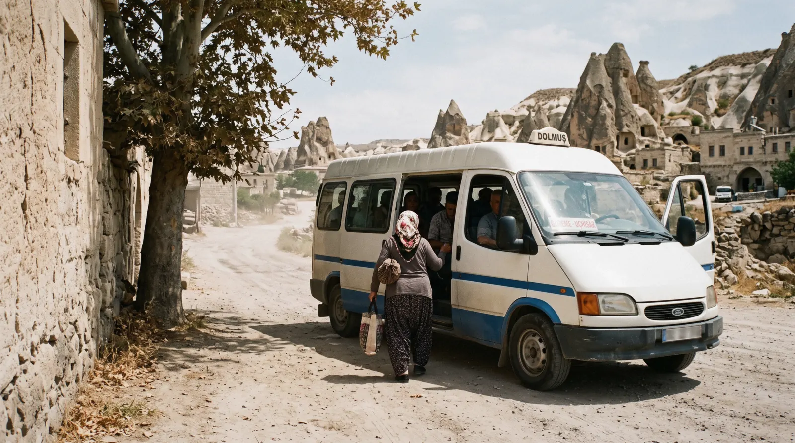 A dolmuş minibus on a Cappadocia road between tuff ridges and vineyards